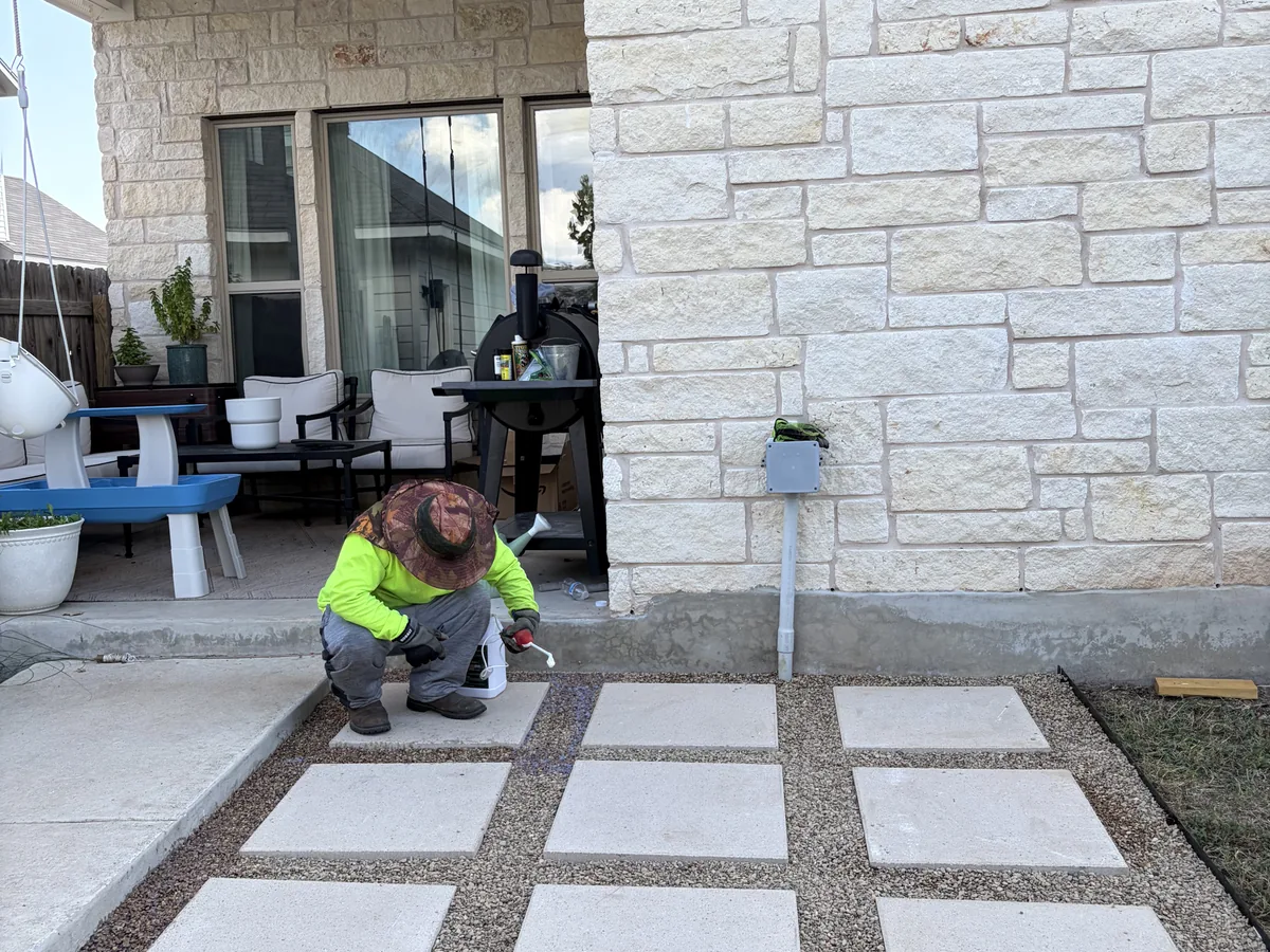 Large square pavers set with gravel joints beside a home