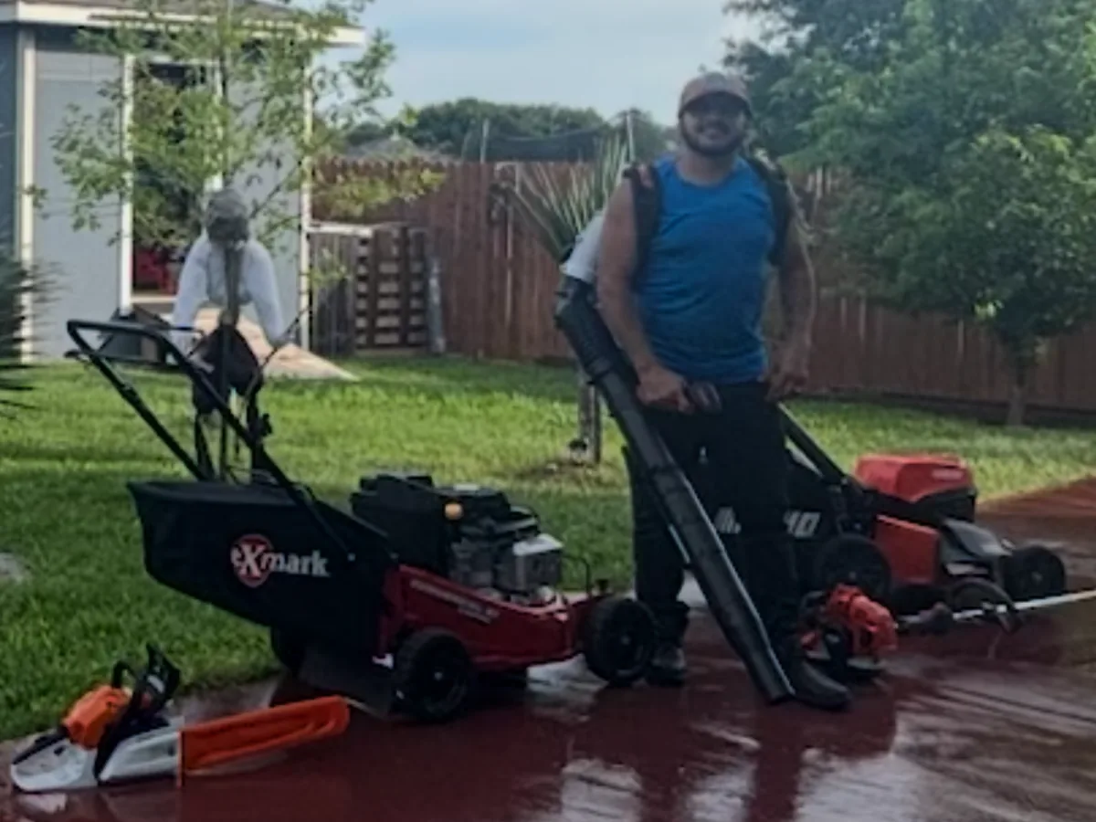 Commercial zero turn mower, backpack blower and string trimmers on a lawn